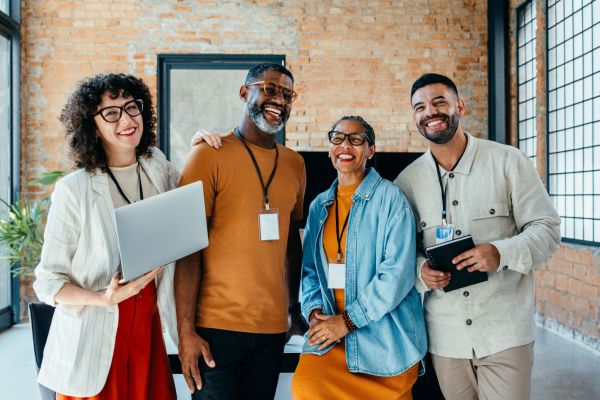 Vier Kollegen im modernen Büro, diverse Teamarbeit und Zusammenarbeit. 