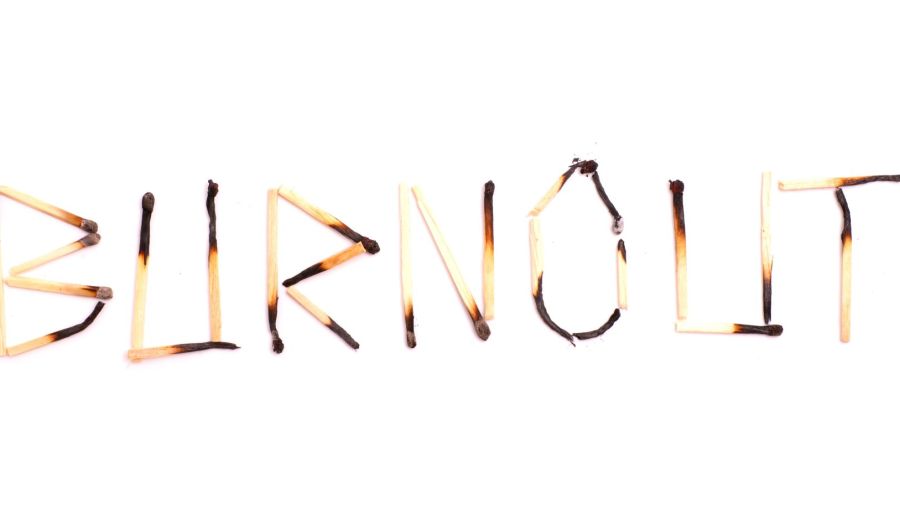 Ausgebrannte Streichhölzer formen das Wort Burnout: Symbol für Erschöpfung und mentale Überlastung.