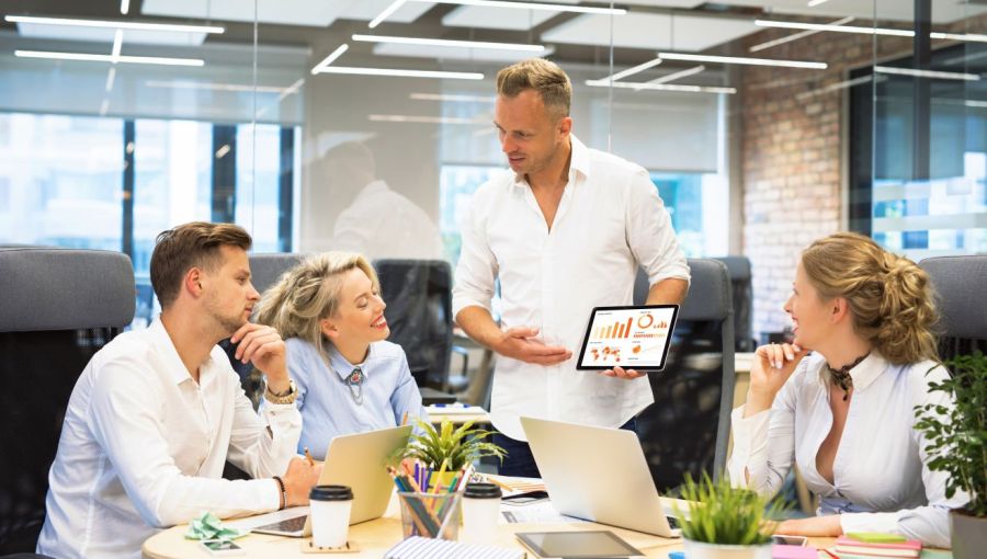 IT-Projektleiter präsentiert Team-Dashboard auf Tablet im modernen Büro.